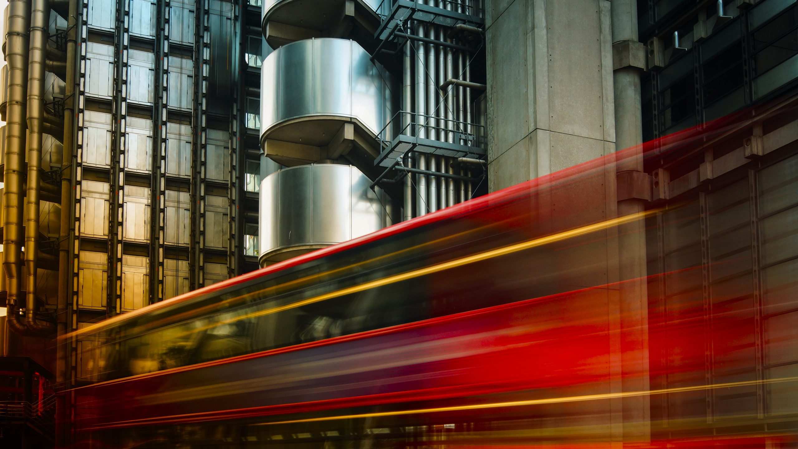 A London bus speeds past the Lloyd's building