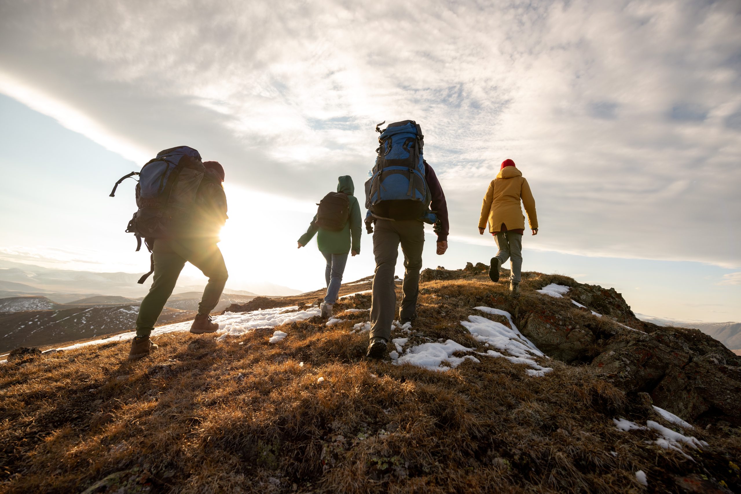 Hikers reaching the summit of a snowy mountain